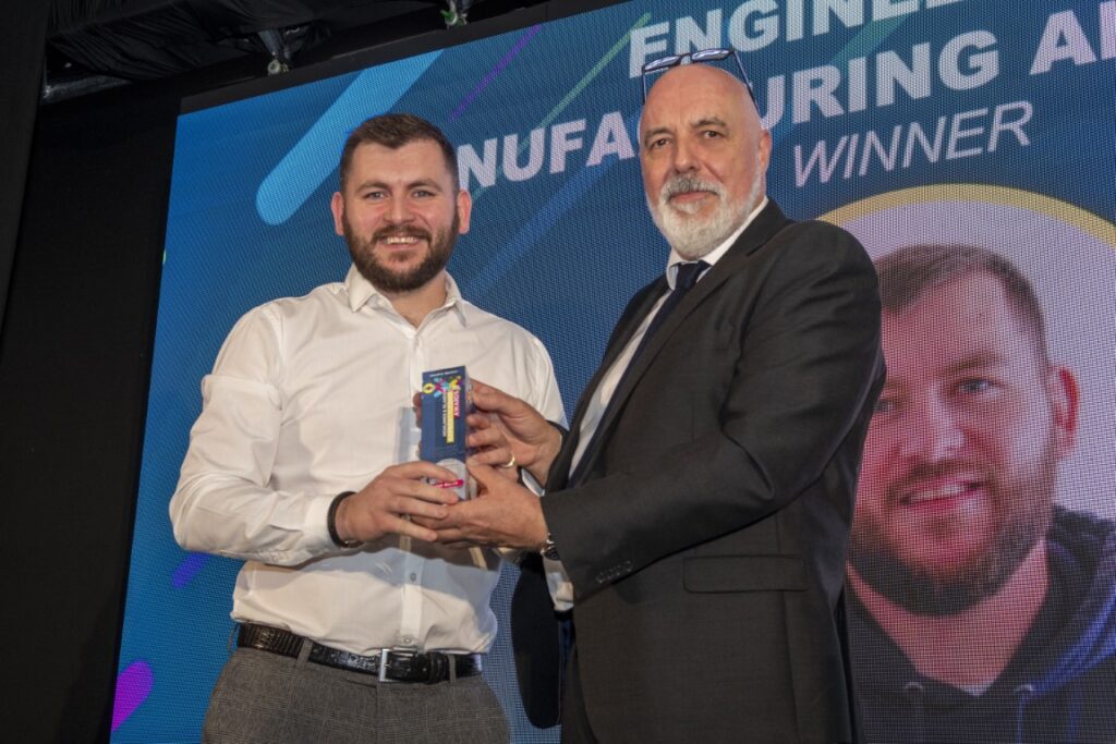 Two men holding an award on stage