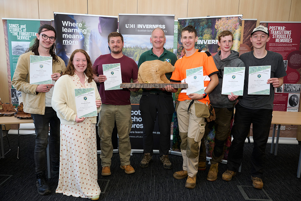 College students holding certificates at a prizegiving College students holding certificates at a prizegiving