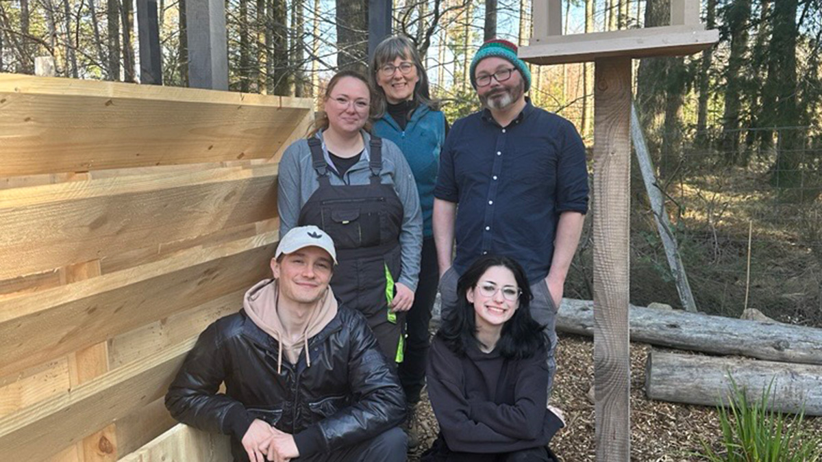 Students standing around the tea shed they built