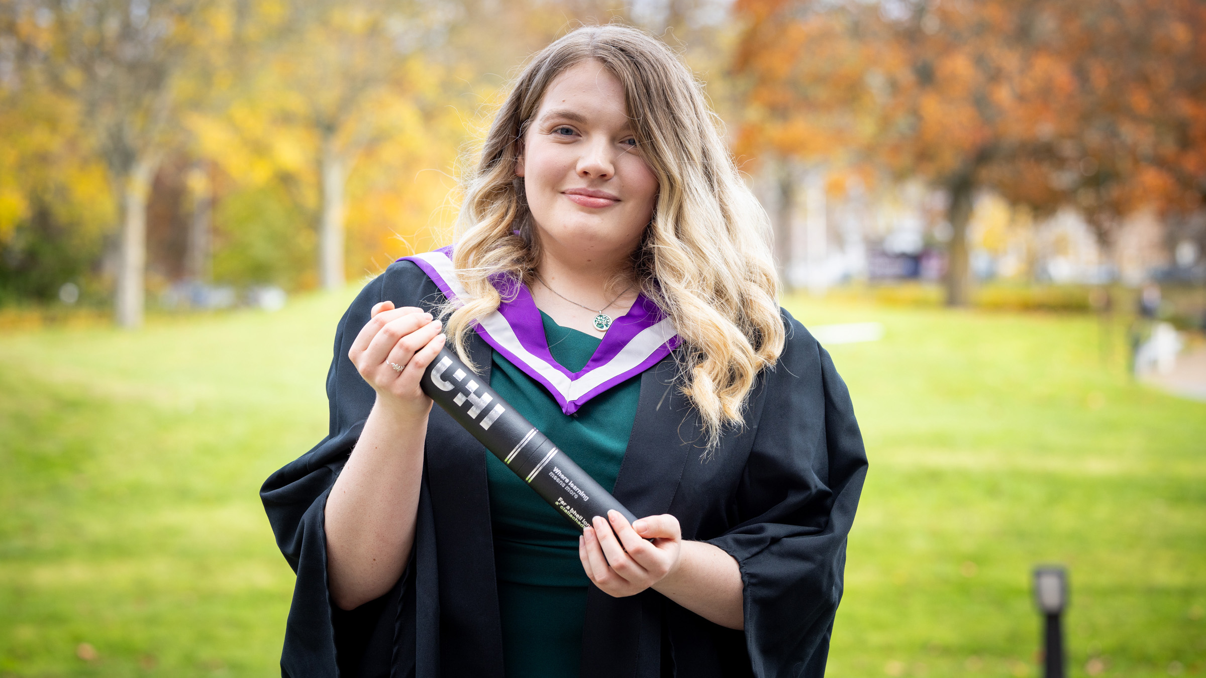 Female student smiling with scroll