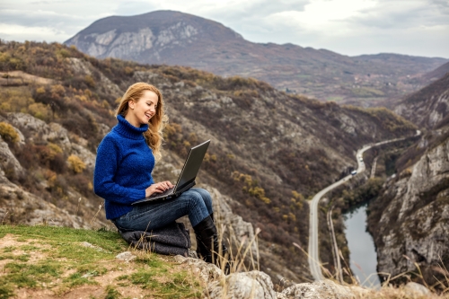 Person using a laptop up a hill