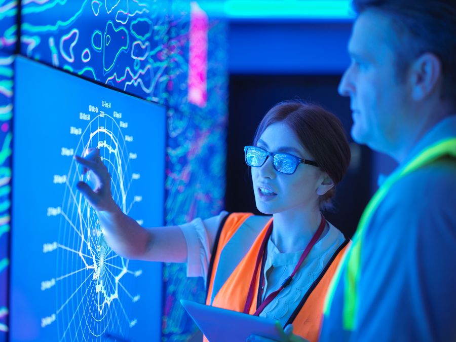 Two people looking at a large digital map Two people looking at a large digital map