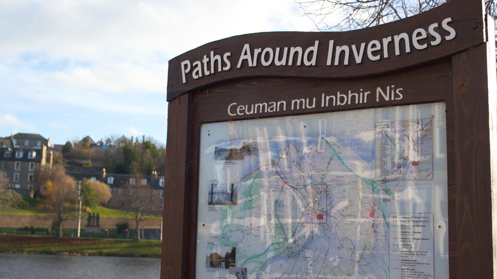 A signpost with a map titled 'Paths Around Inverness'