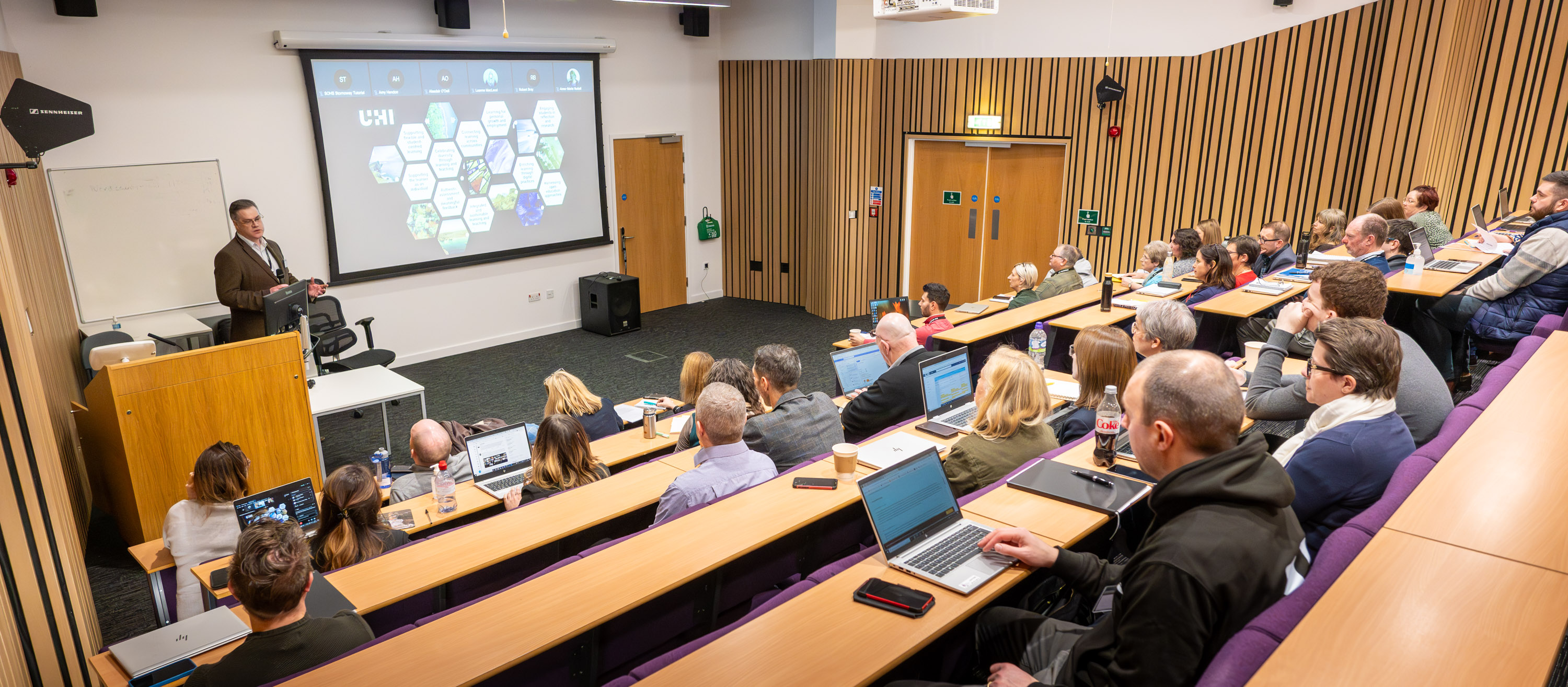 People in a lecture theatre listening to a lecturer