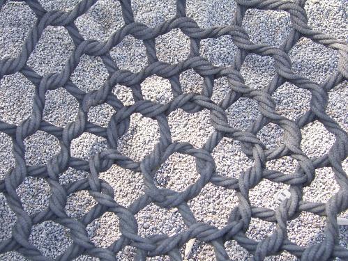 A rope net above some gravel A rope net above some gravel