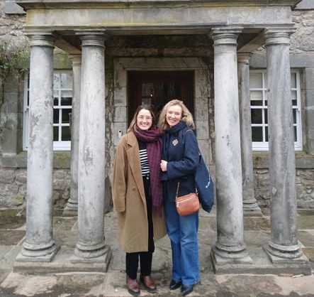 Two women standing in front of a portico with a colonnade. Two women standing in front of a portico with a colonnade.