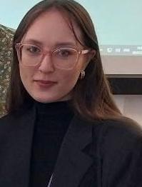 Woman wearing glasses and black clothing looking at the camera