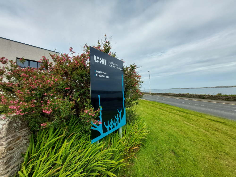 A photograph of the INS sign outside the building in Orkney