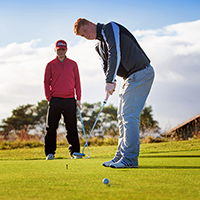 Two people playing golf
